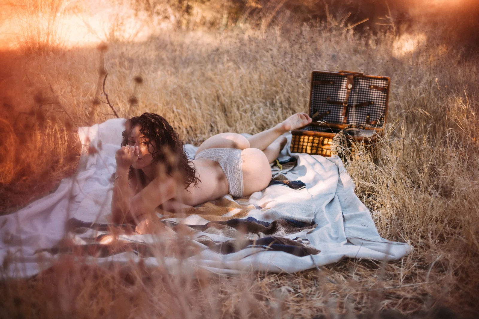 Woman in lingerie on a picnic blanket in golden California grass — fine art outdoor portrait