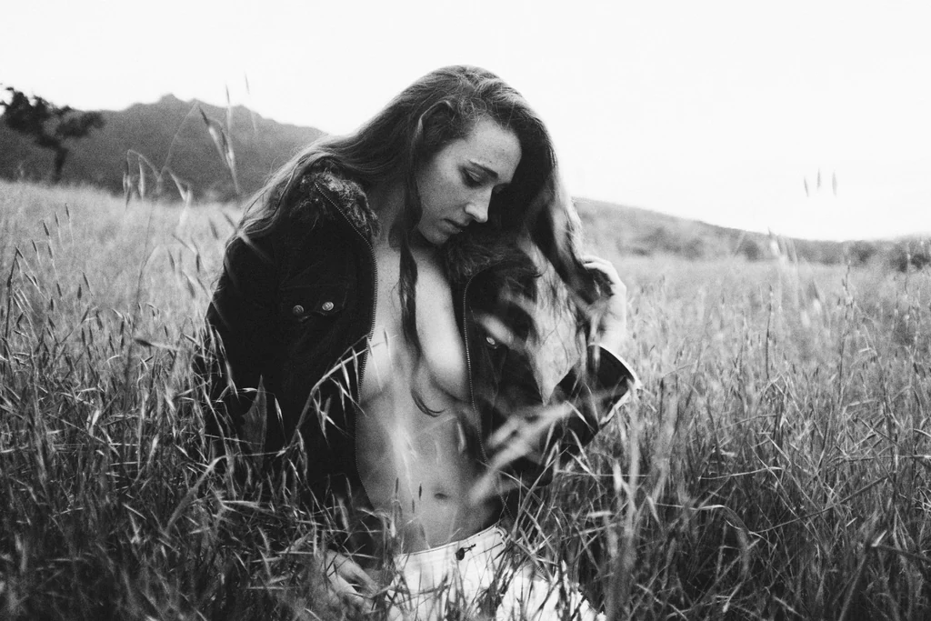 Black and white portrait in an open meadow, mountains beyond
