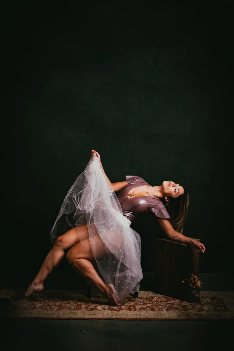 Figure in motion with a tulle skirt, teal backdrop